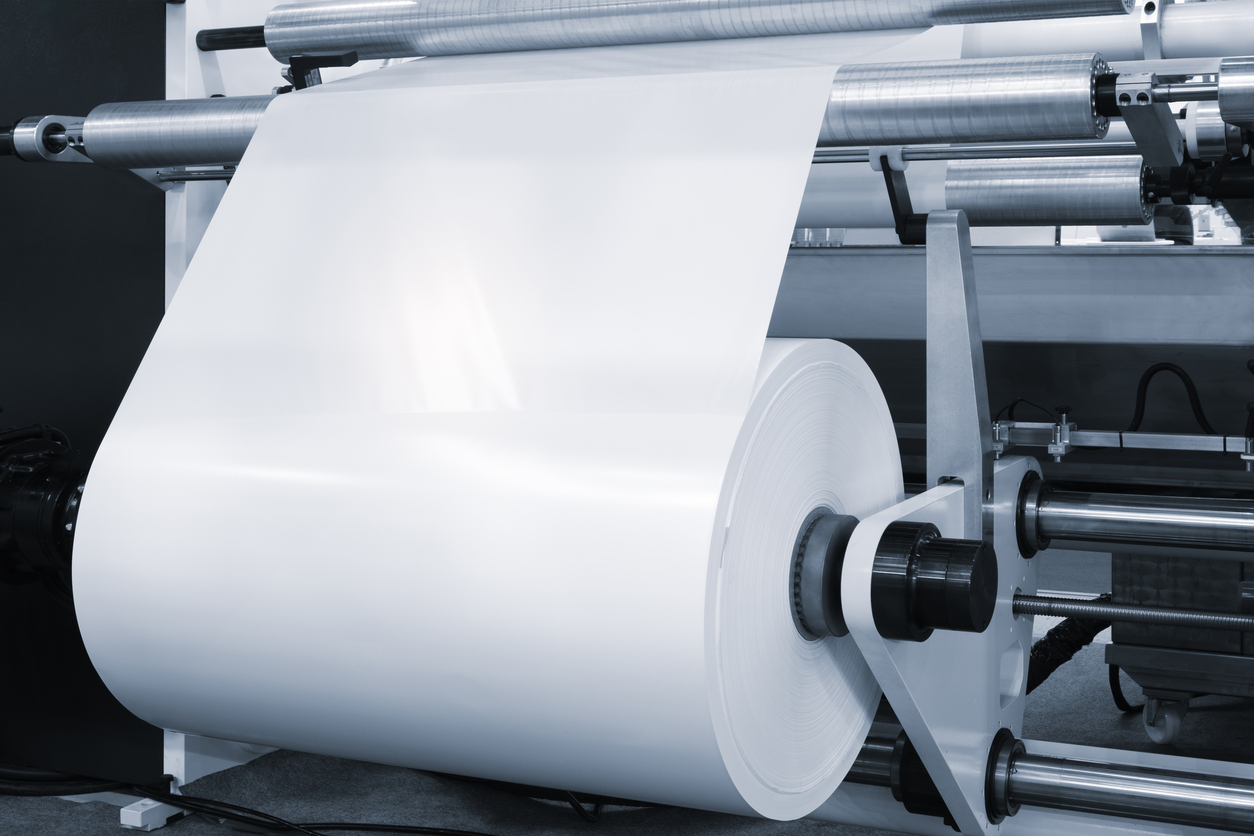 Automatic polyethylene plastic bag production machine with lighting effect. Close-up of the roller of the plastic bag production machine in the light blue scene. product packaging concept